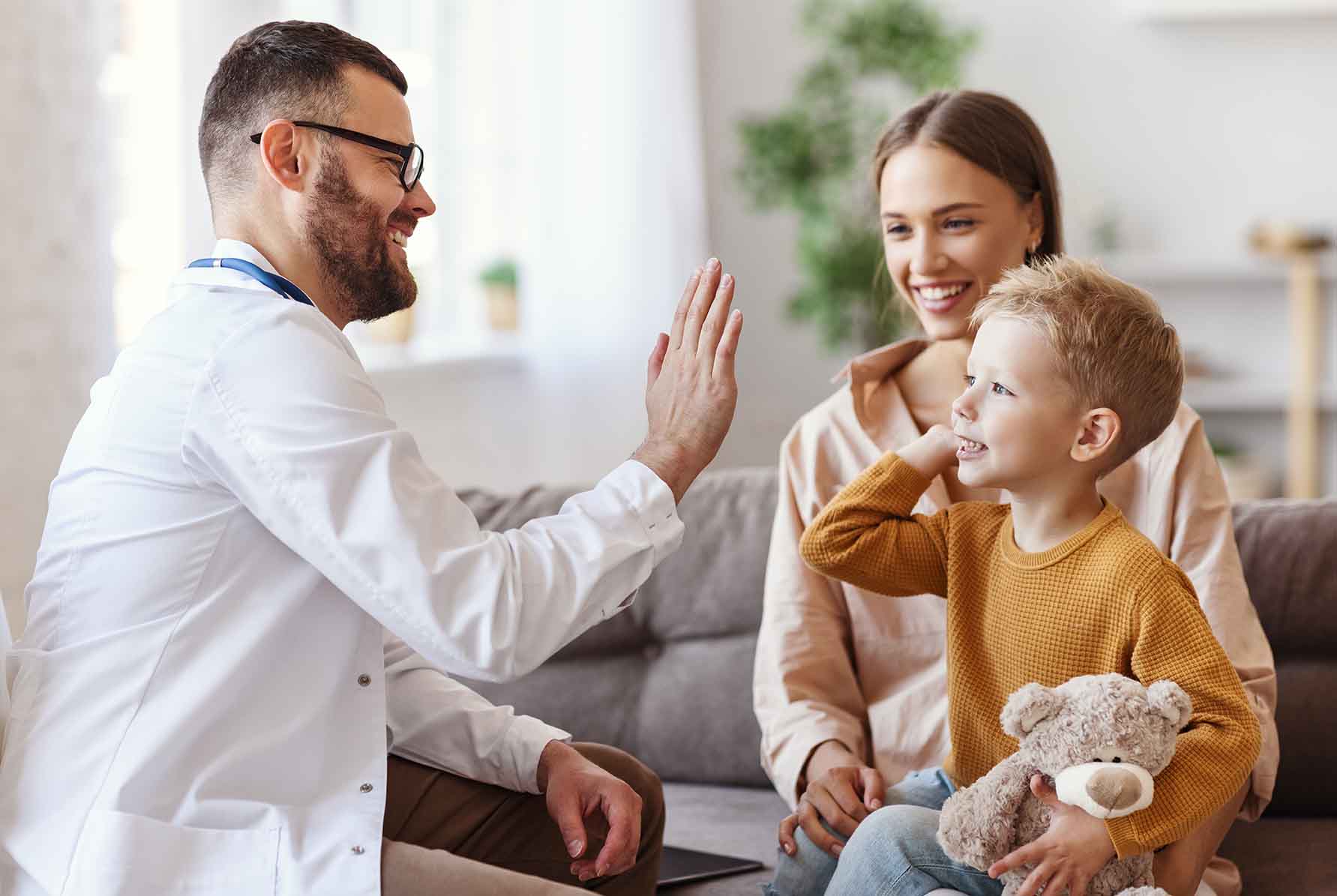 Happy Child High-Fiving a Doctor with Mother in the Background